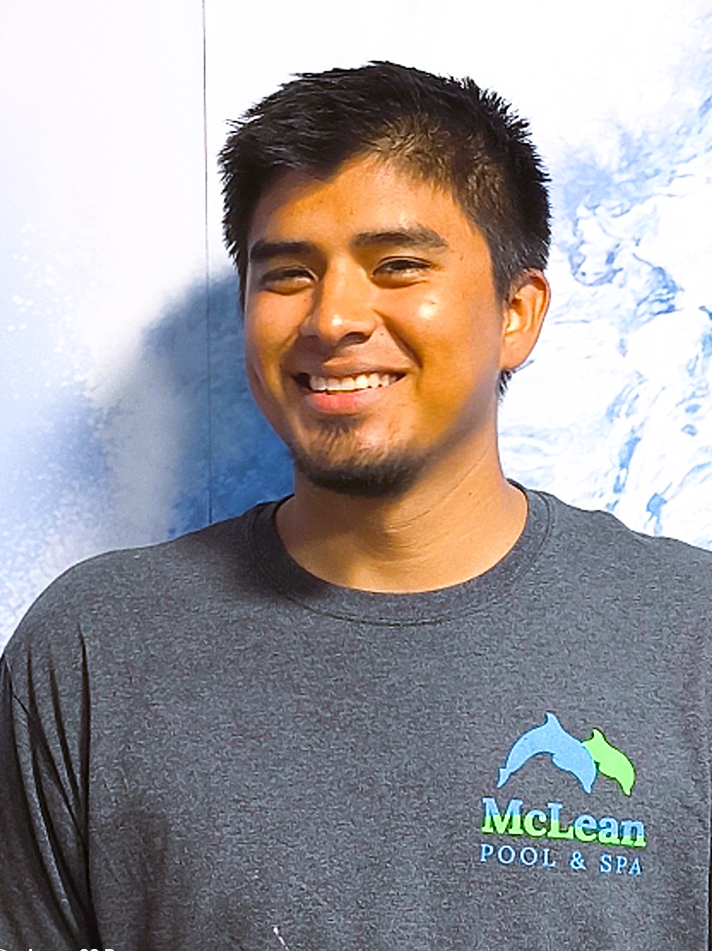 Christian Lopez, McLean Pool & Spa lead pool technician, smiling and wearing company uniform.